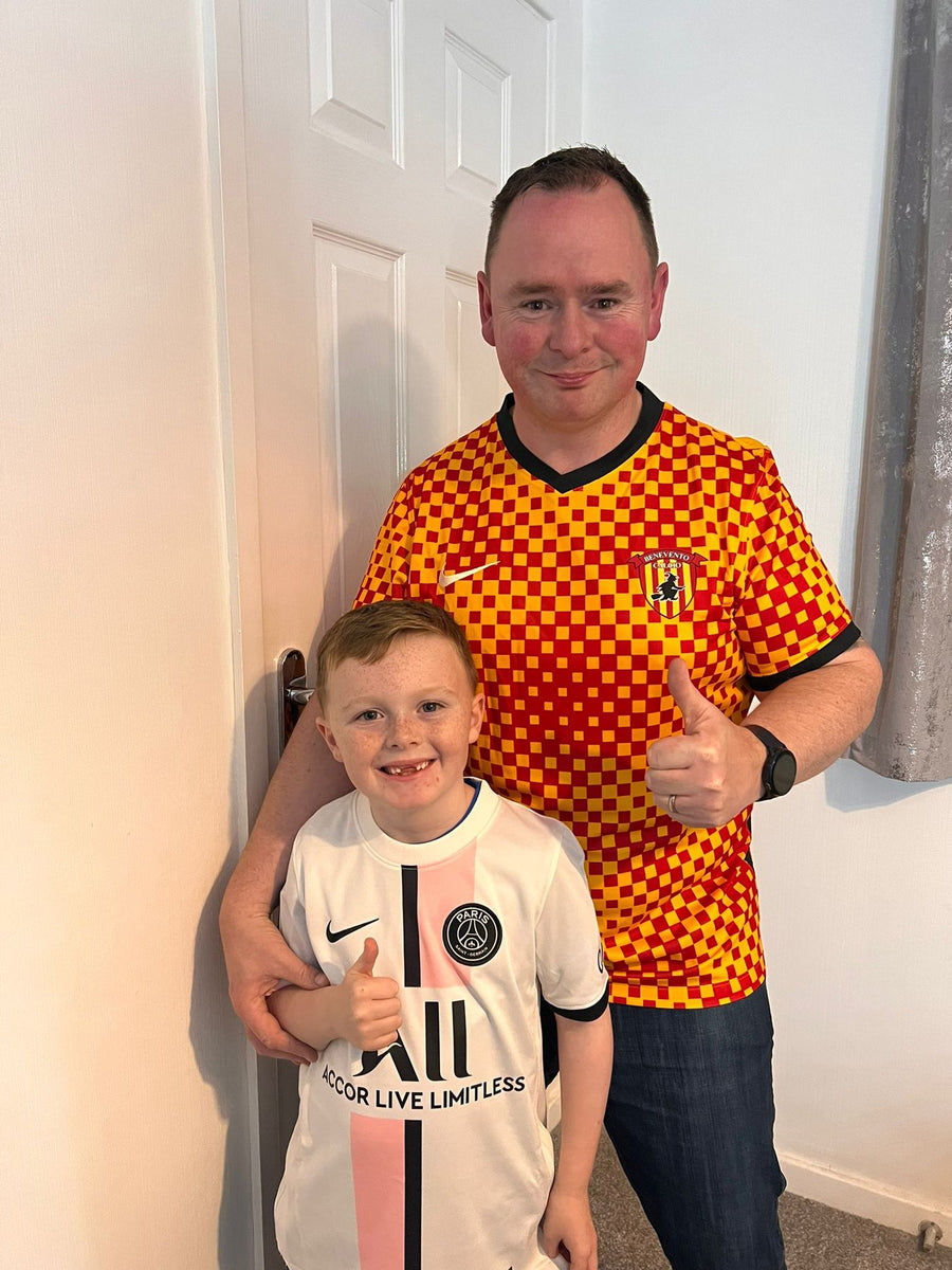 Young MJK customer in a PSG away shirt giving a thumbs up with his dad