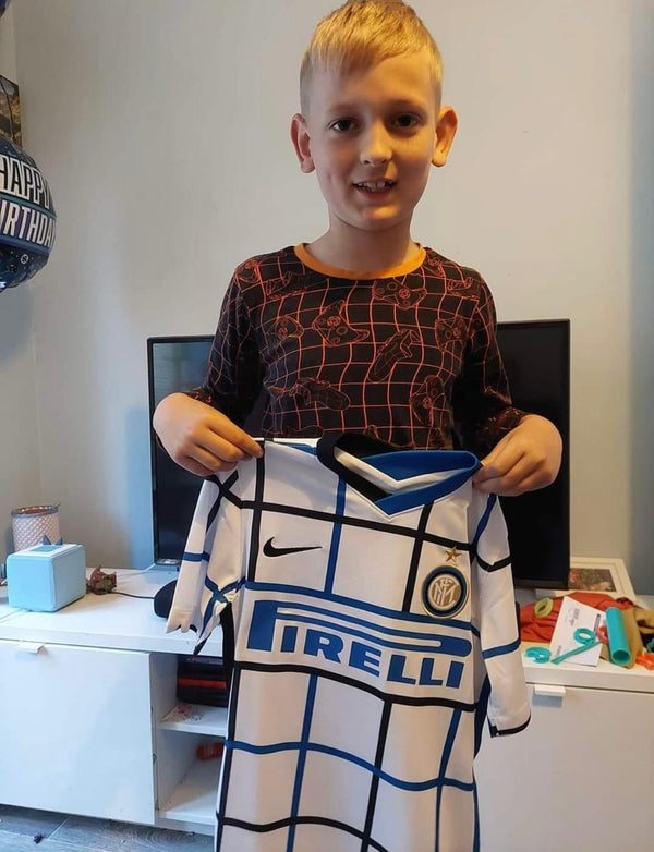 Young MJK customer holding up a genuine Inter Milan away shirt from his Kids' Mystery Football Shirt Box